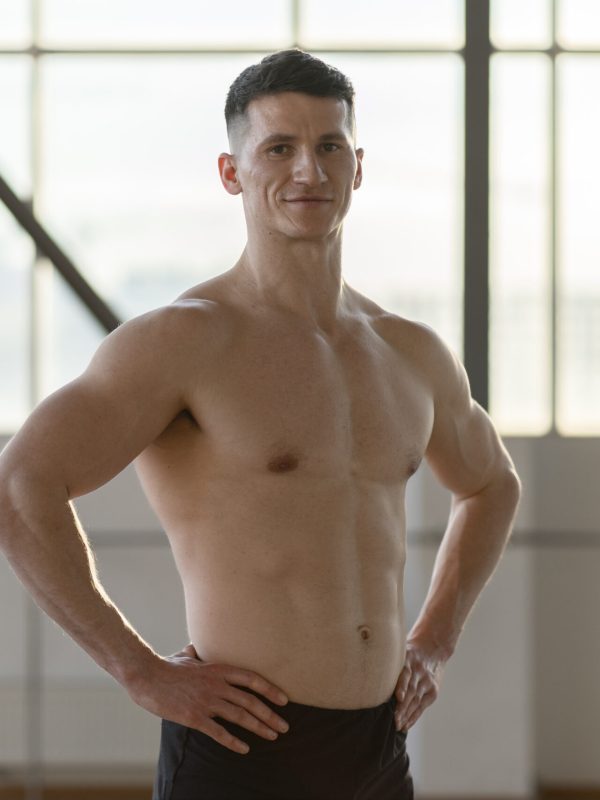 Smiling hispanic athlete standing indoors looking at camera. Healthy lifestyle concept